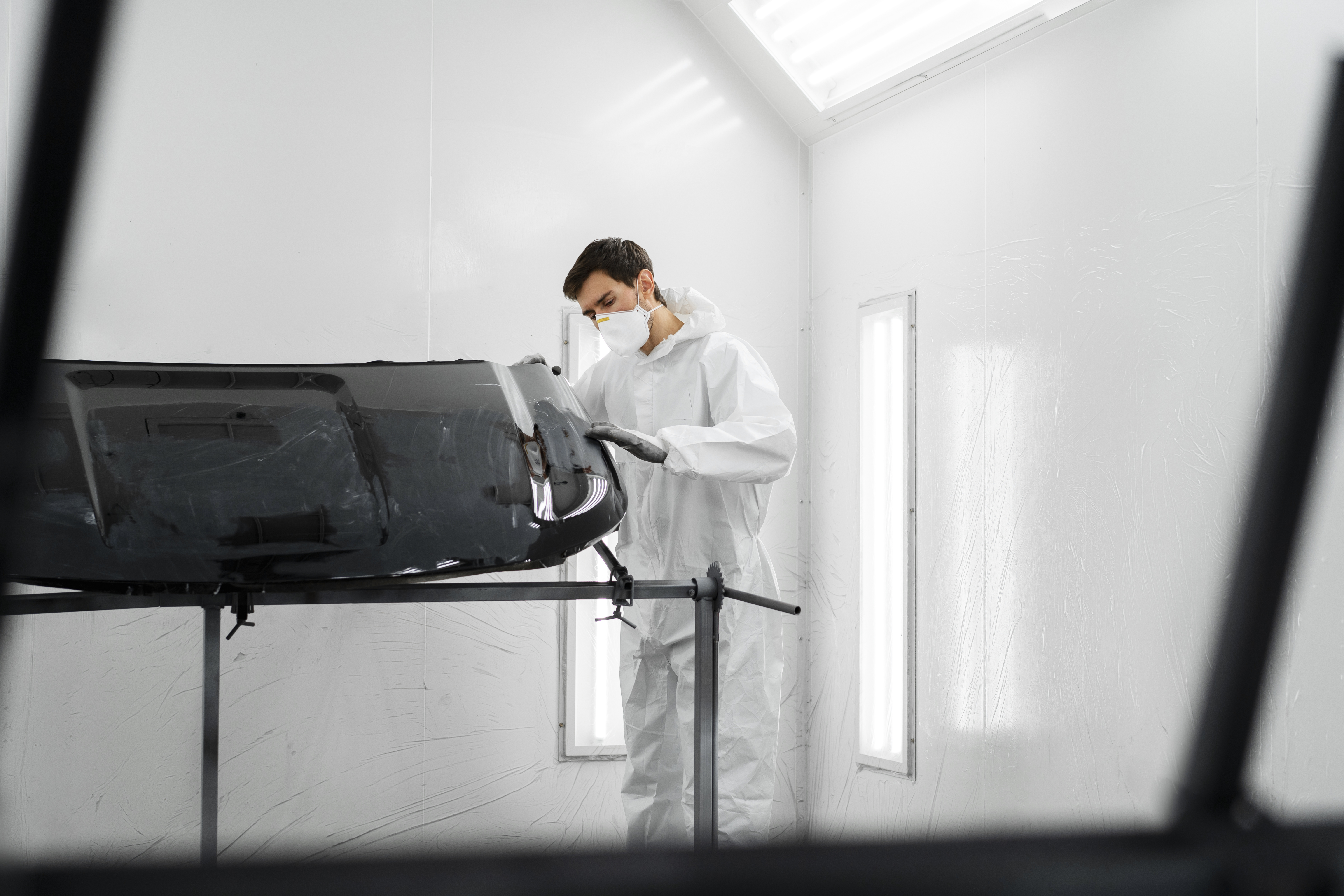 male painter hazmat suit inside car shop